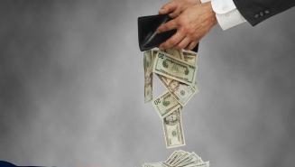 Businessman opening wallet with cash falling out into Uncle Sam’s hand