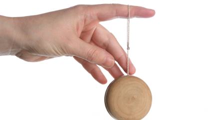 hand holding yoyo, isolated over white