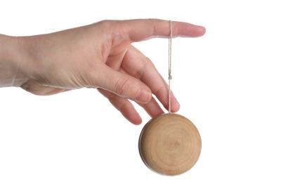 hand holding yoyo, isolated over white